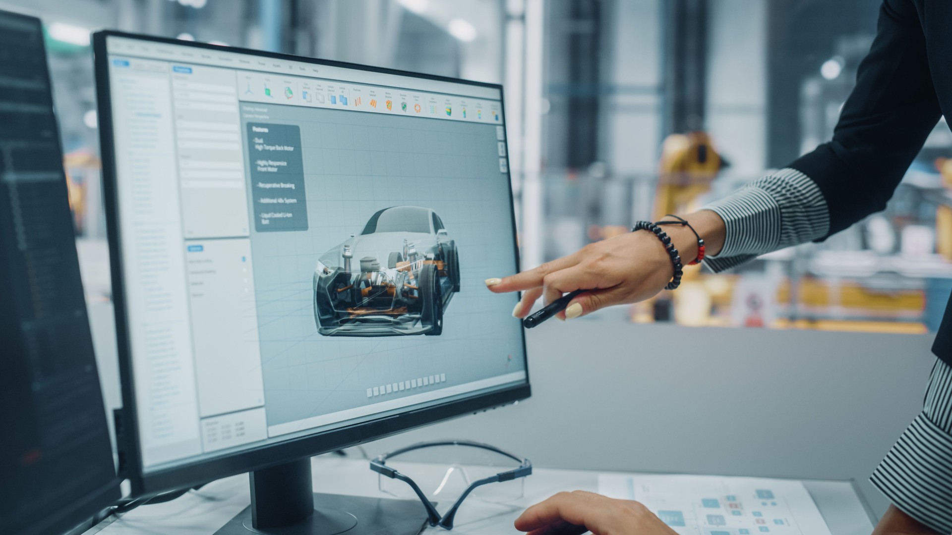 Two Automotive Engineers Discussing Concept Car Blueprints on Desktop Computer in Modern Office at Assembly Plant. Female Industrial Project Manager Talk to Male Designer at Vehicle Factory.